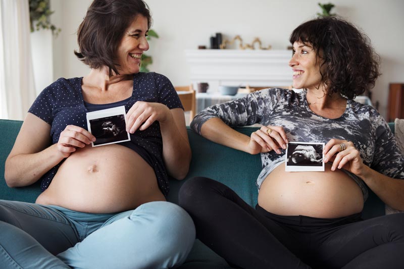 two pregnant women smiling