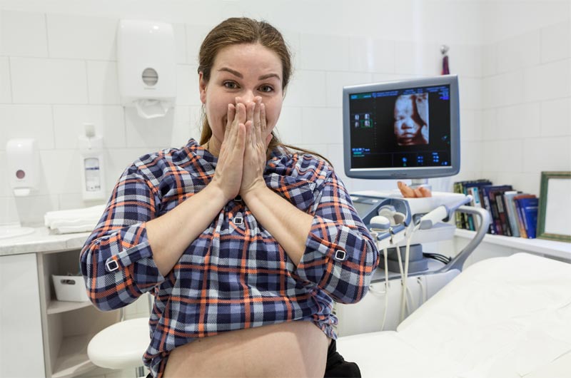 Pregnant woman excited about prenatal ultrasound at OB/GYN office