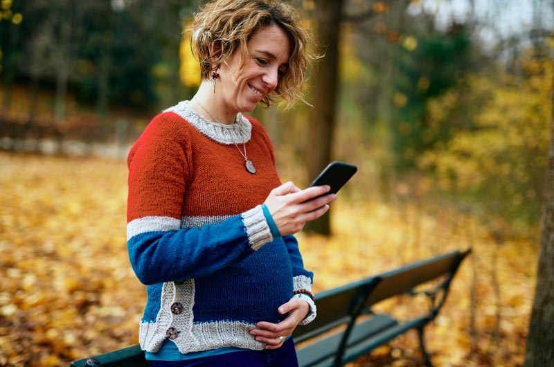 pregnant woman looking up information on her phone